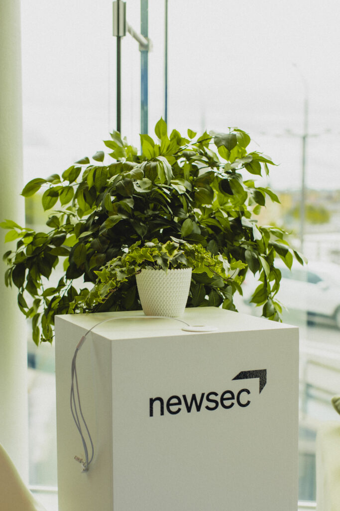 Grønne planter på Newsec skranke symboliserer bæredygtig ejendomsrådgivning