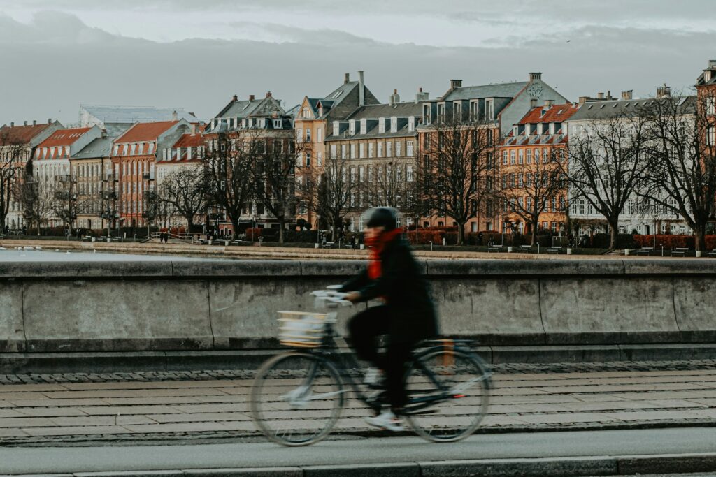 Cyclist by Copenhagen lakes with historic buildings in the background – Newsec property and association advisory