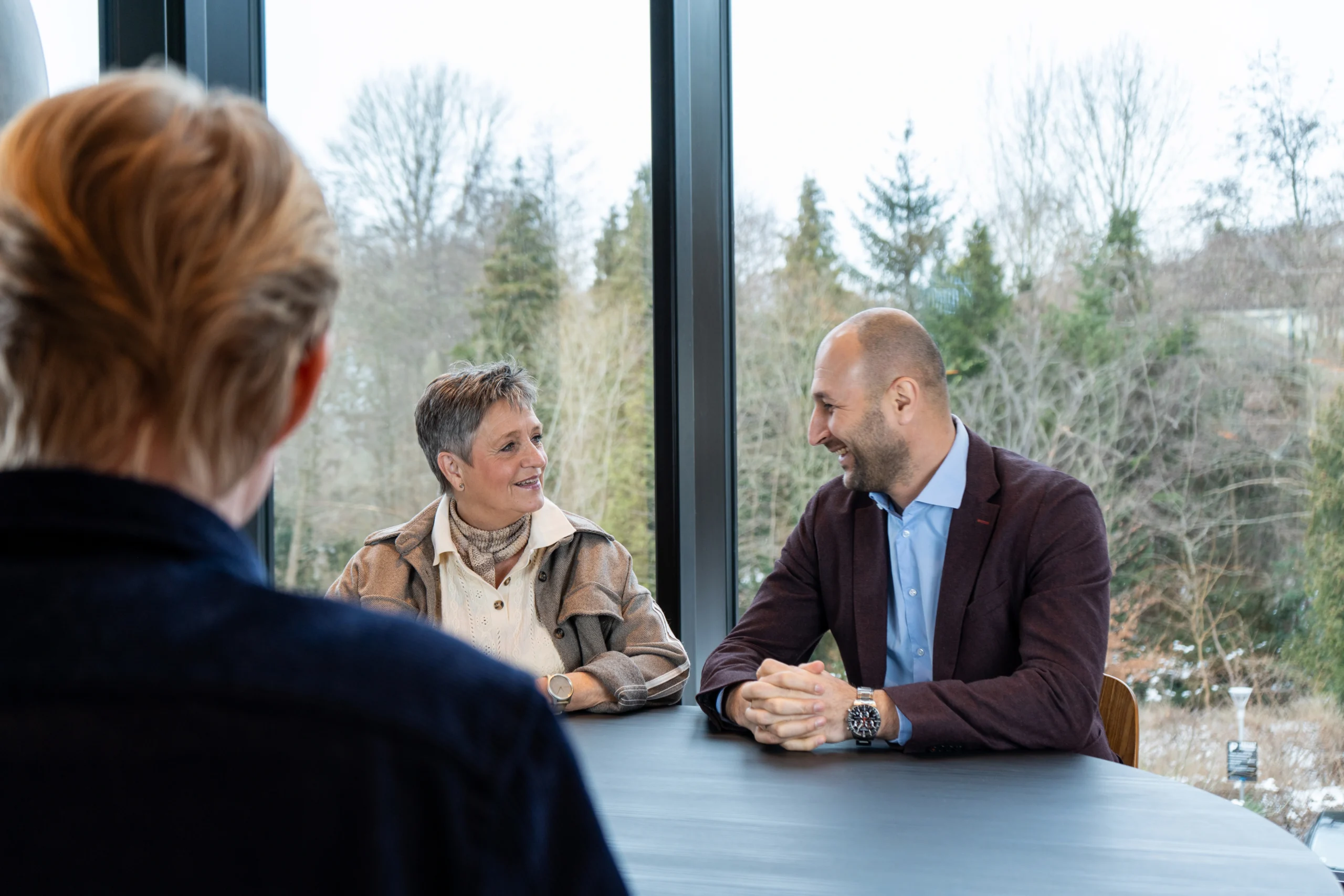 Newsec-rådgivere i dialog ved laptop og kaffe, der sikrer ejendomsadministration og professionel foreningsadministration